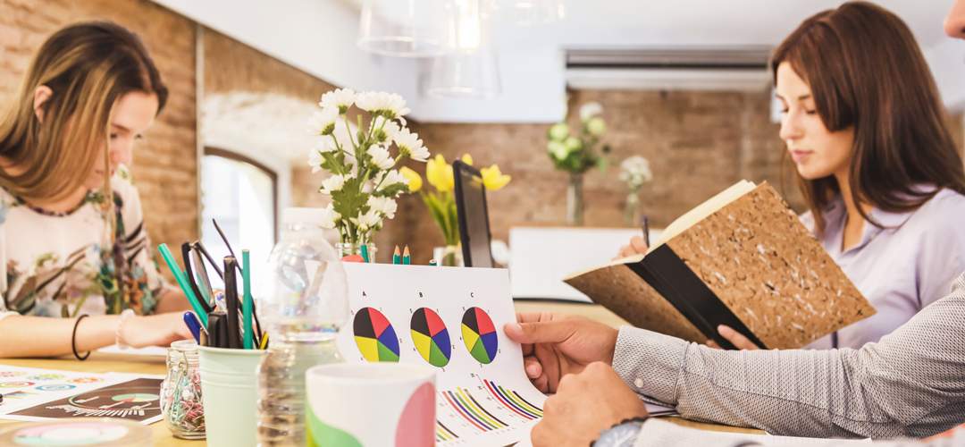 Étude de marché pour une franchise — méthode et outils pour réussir Deux professionnelles analysant des données et graphiques pour réaliser une étude de marché avant d'ouvrir une franchise